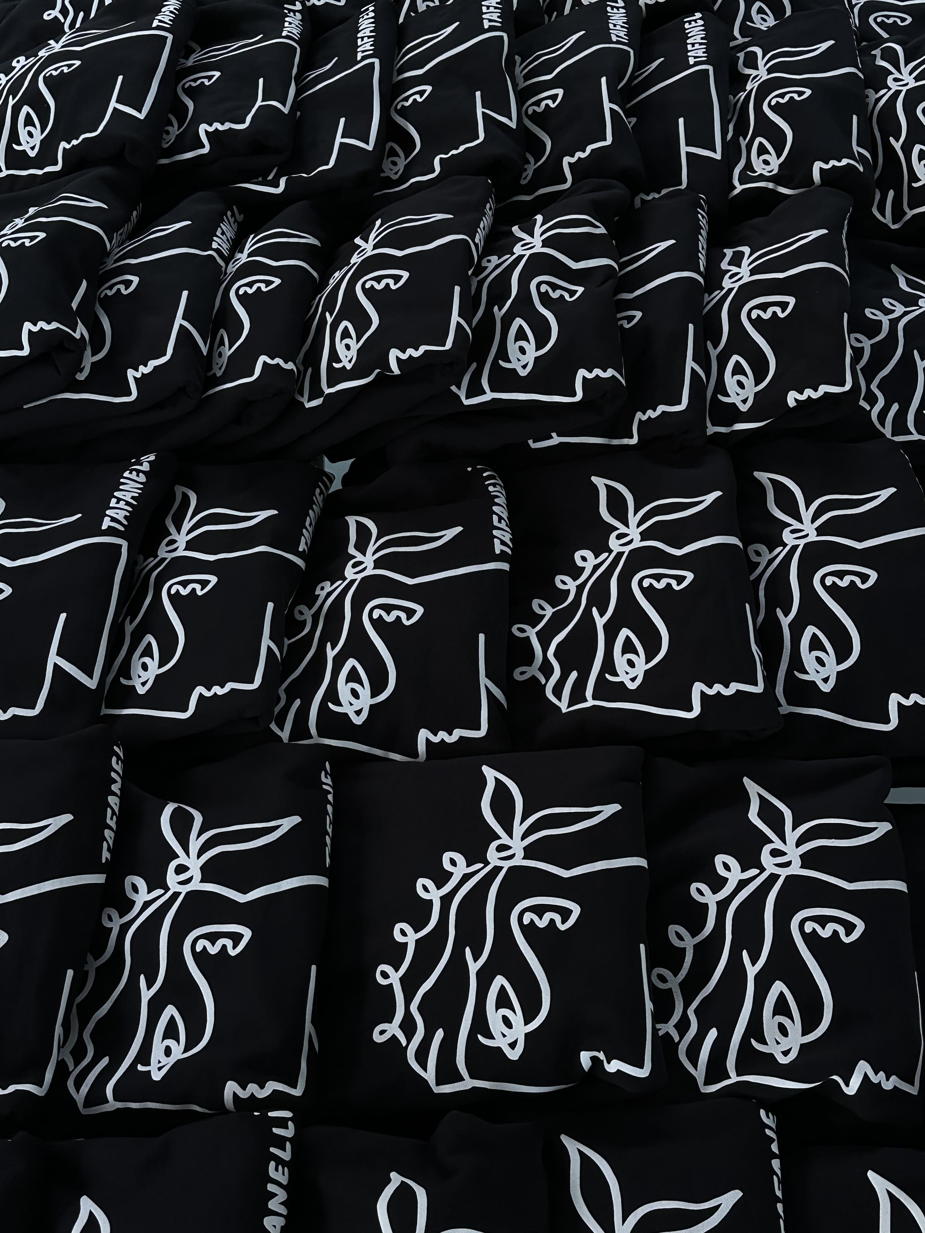 Hoodie Tafanelli plié avec précision sur une valise en toile claire, lumière du matin, symbole du voyage soigné.